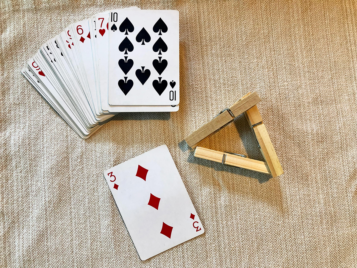 A deck of playing cards and clothespins.