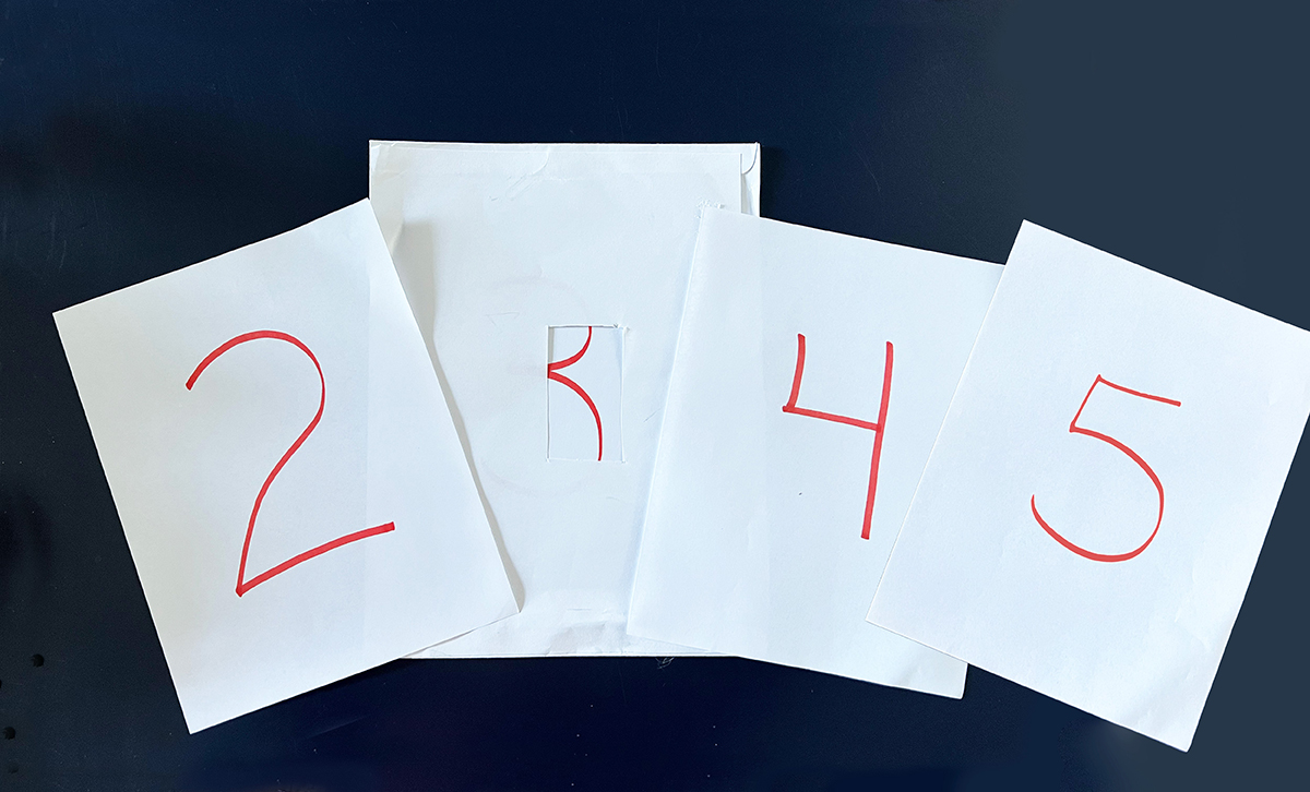 Handwritten numbers on pieces of paper.