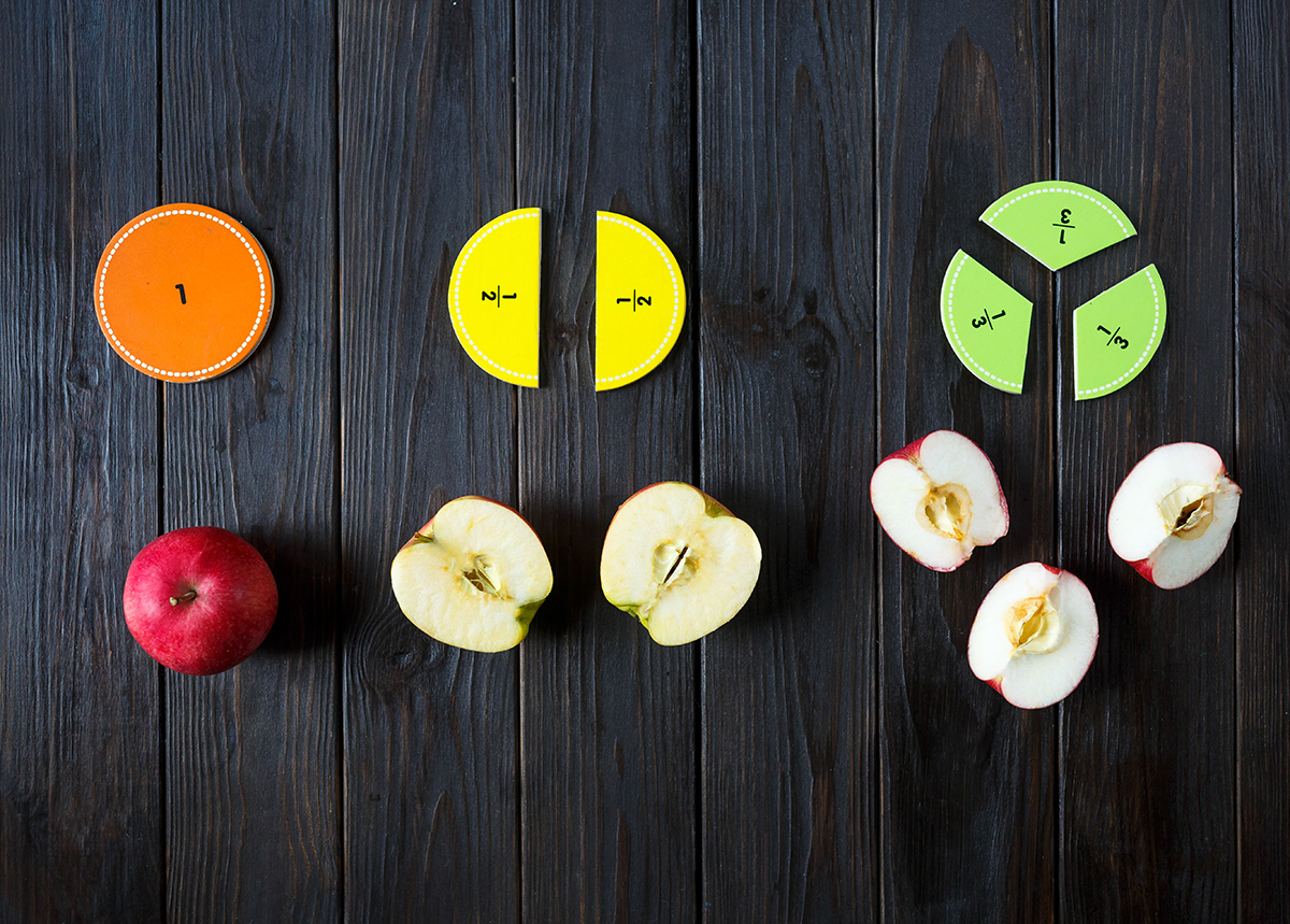 Apples cut into pieces to represent different fractions.