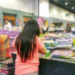 A young girl looking at books at a homeschool convention booth.
