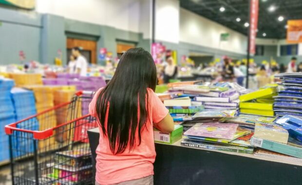 A young girl looking at books at a homeschool convention booth.