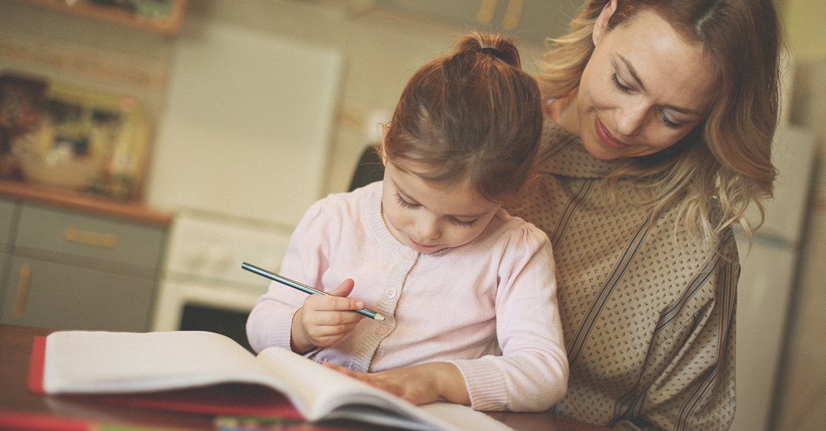 A young girl and her mother work on homework together.