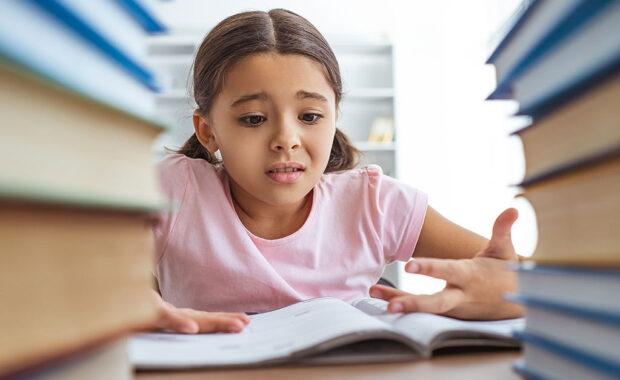 A student looks at her homework with a worried look on her face.