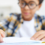 A young boy writing for homework.