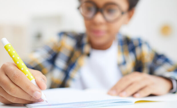 A young boy writing for homework.