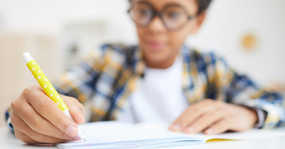 A young boy writing for homework.