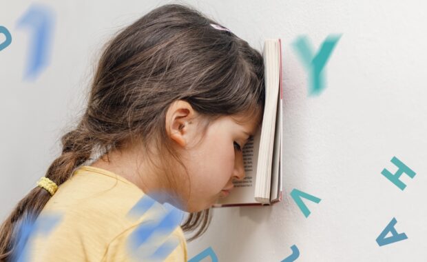 A frustrated young girl has her head in her book.