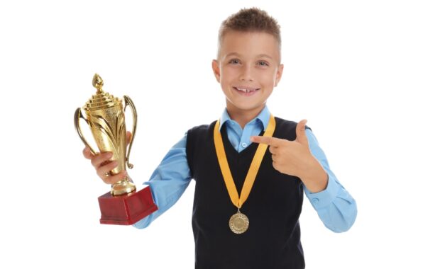 A young student holds a trophy.