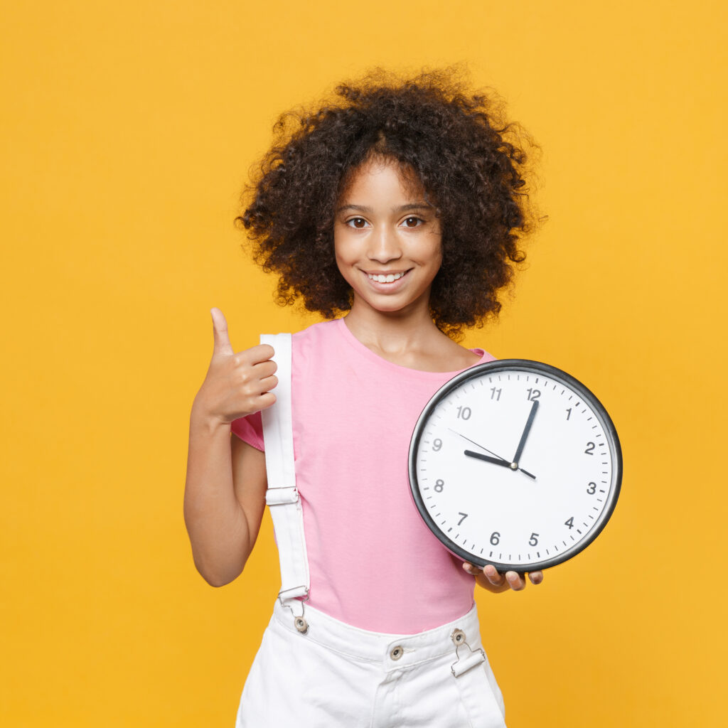 A young student holds a clock.