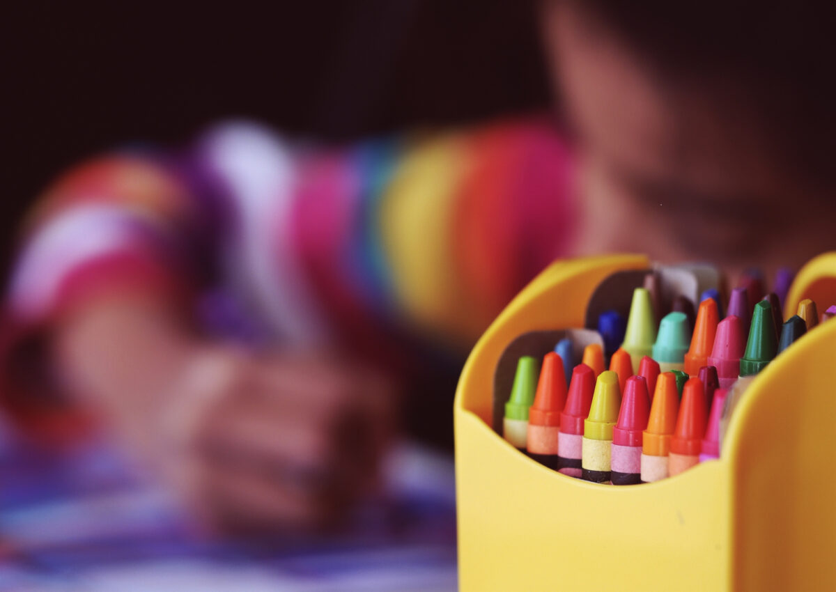 A young student coloring with crayons.