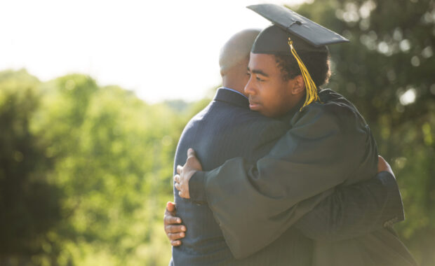 Father hugging his son on his graduation day.
