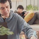 A parent working from home with their kids in the background.