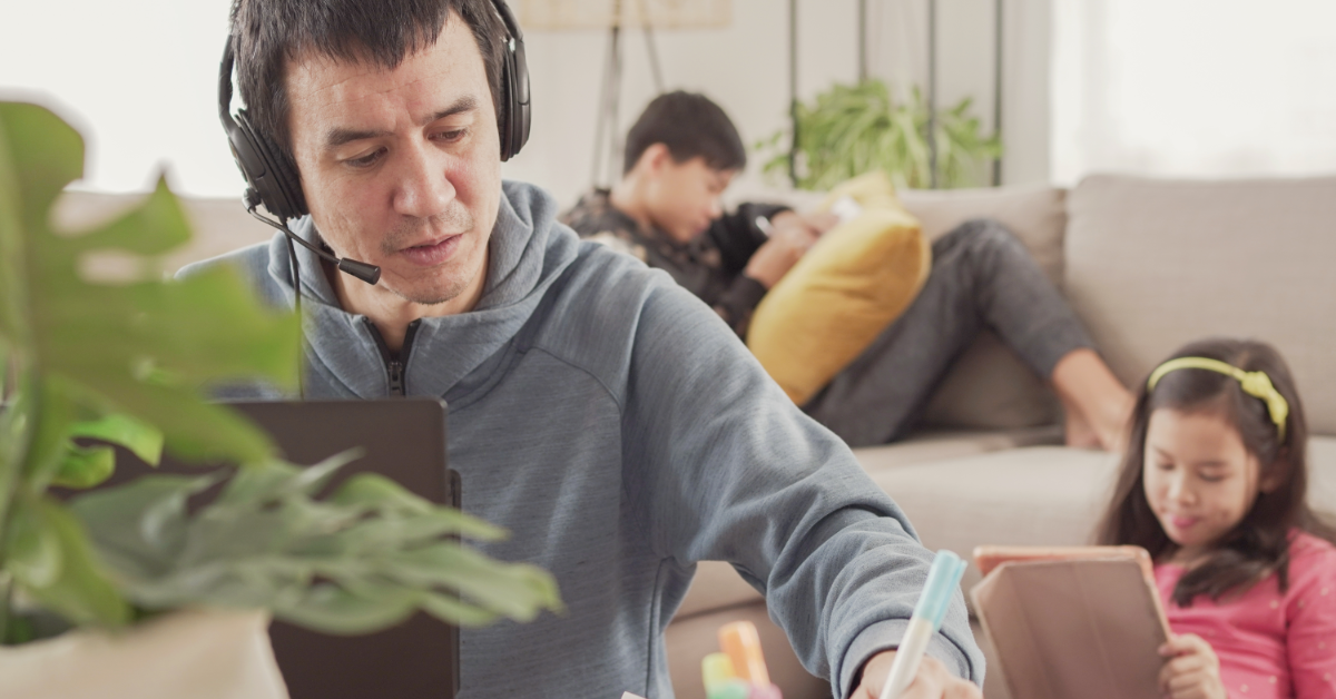 A parent working from home with their kids in the background.