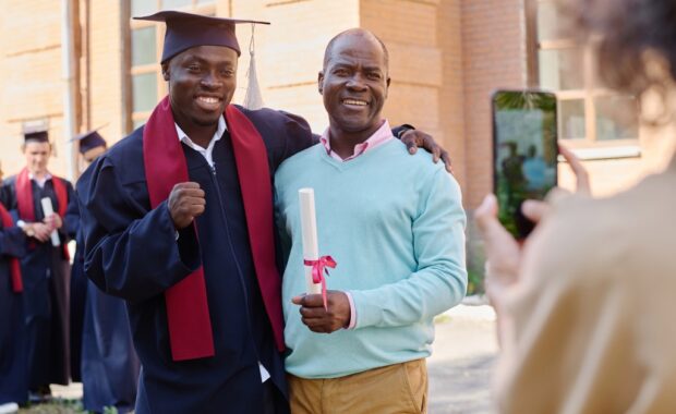 A parent with their high school student at their graduation.