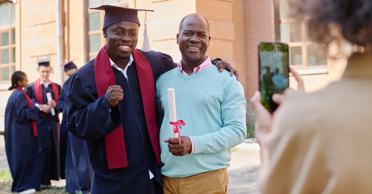 A parent with their high school student at their graduation.