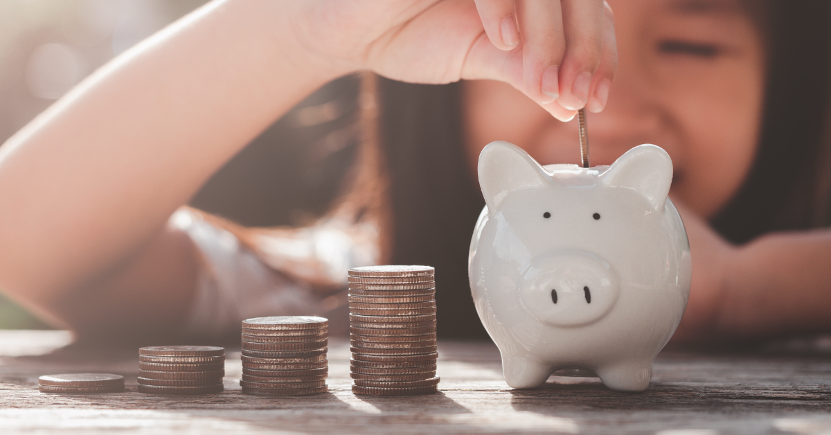 A child puts money in their piggy hank