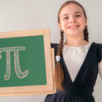 A student holding a chalkboard with the symbol for pi on it