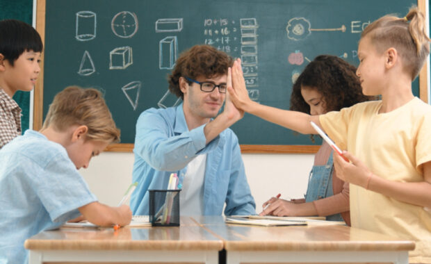 A teacher giving a student a "high five"