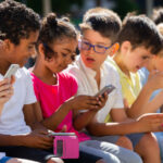 A group of children looking at mobile device screens