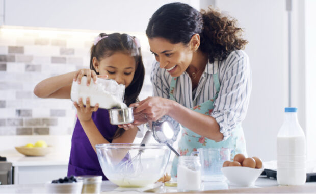 A mother and daughter mixing ingredients together