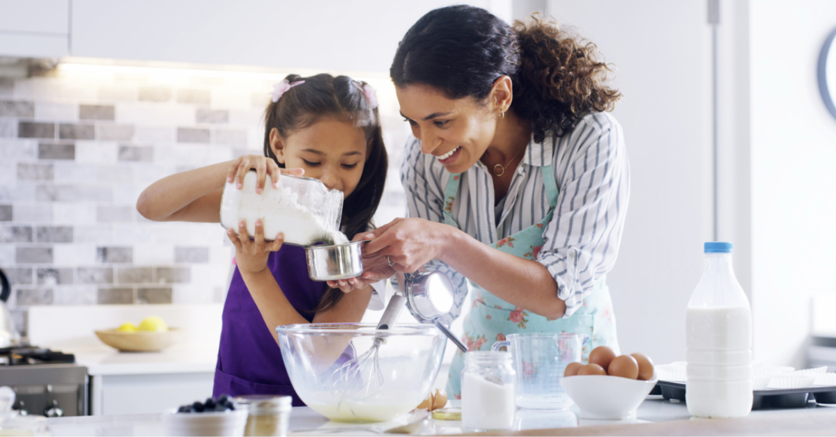 A mother and daughter mixing ingredients together