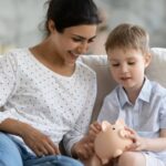 A parent and child learning math with a piggy bank