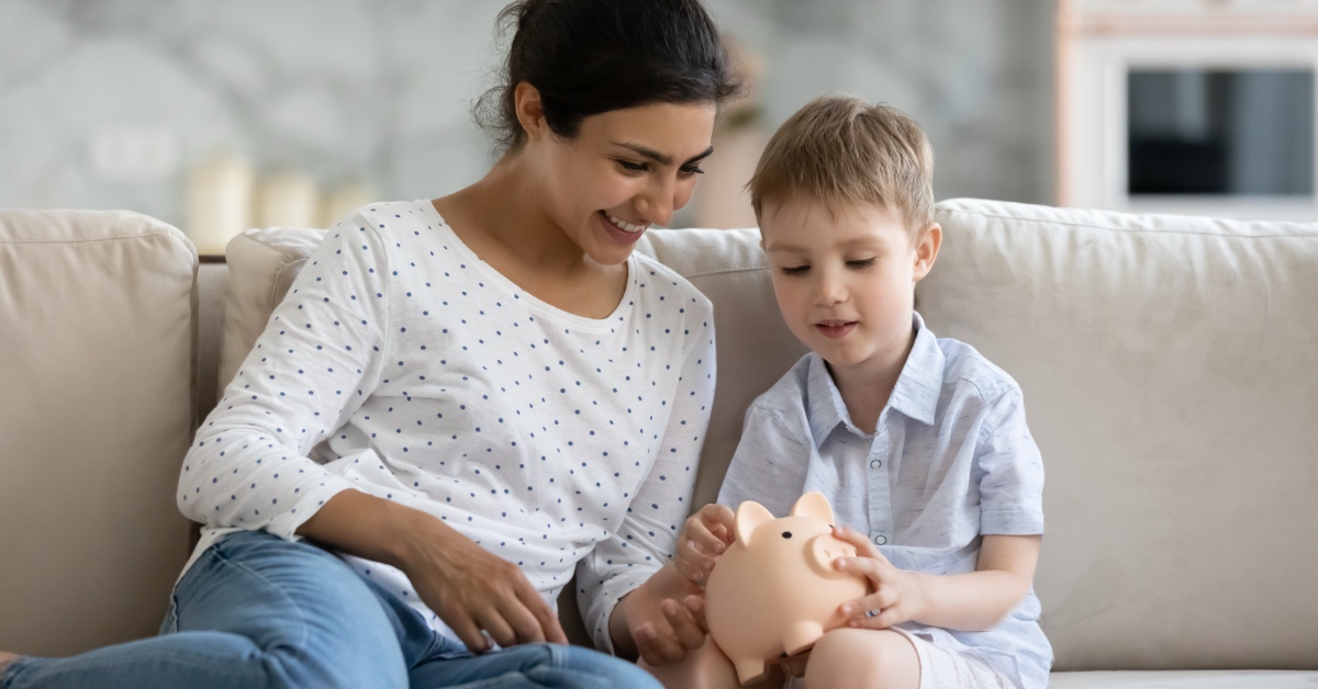 A parent and child learning math with a piggy bank