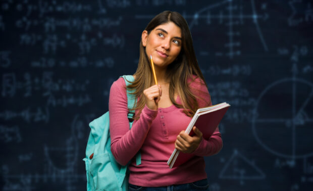 A math student poses in front of a chalkboard