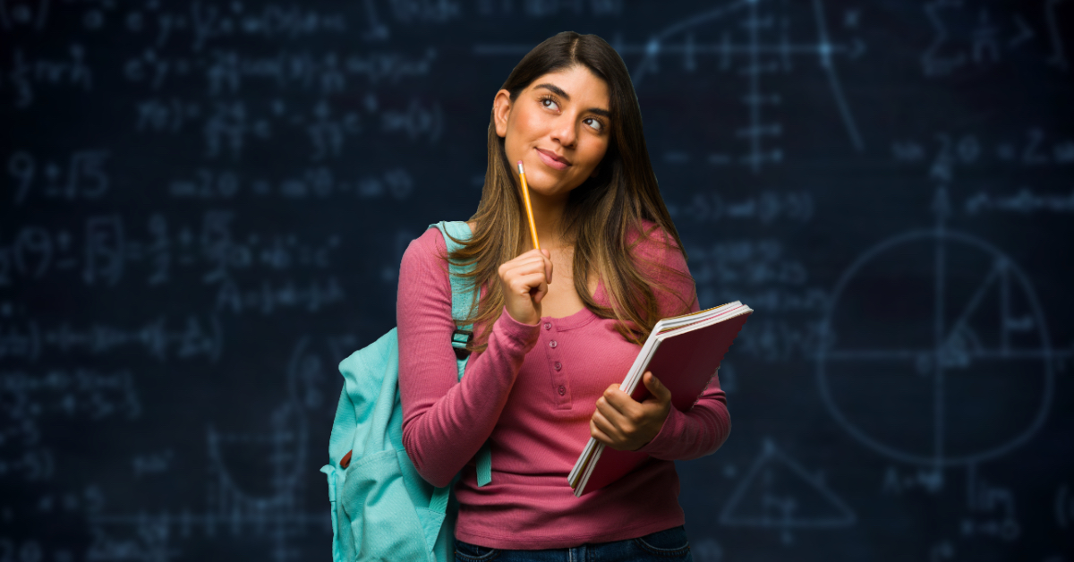 A math student poses in front of a chalkboard