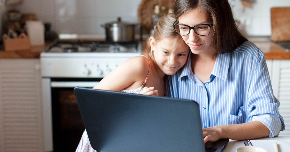 A mother and daughter working on a laptop together