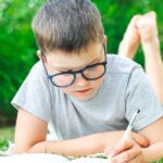 A student writing outside