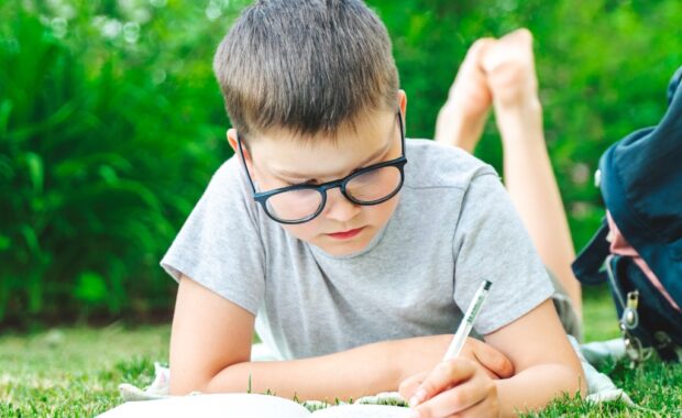 A student writing outside