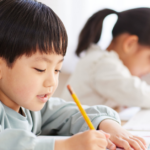 Students writing with pencils