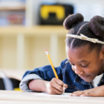 A student writing with a pencil and paper