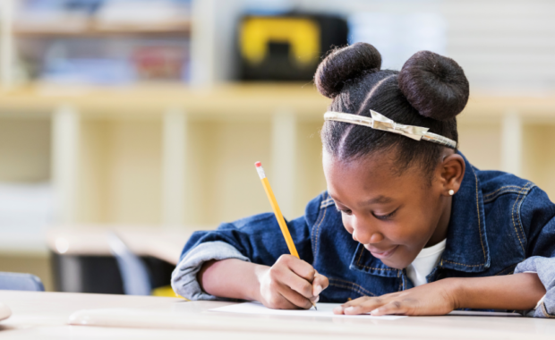 A student writing with a pencil and paper