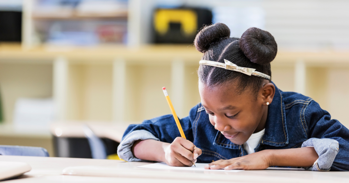 A student writing with a pencil and paper