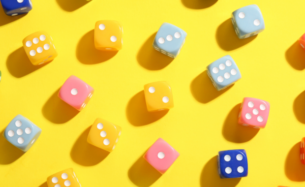 A large amount of 6-sided dice on a table.