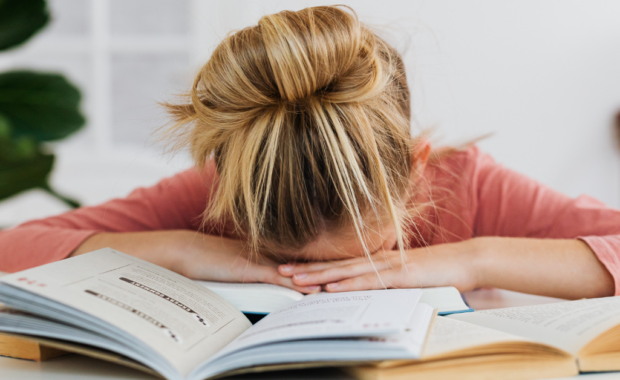 A student slumped over their workbook