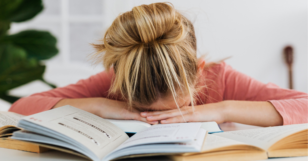 A student slumped over their workbook
